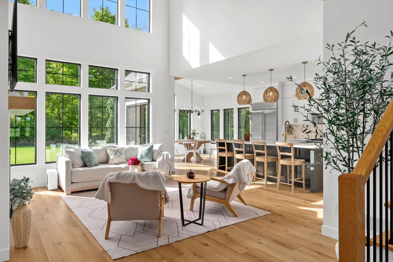 Sunlit double-height living room and kitchen with tall windows