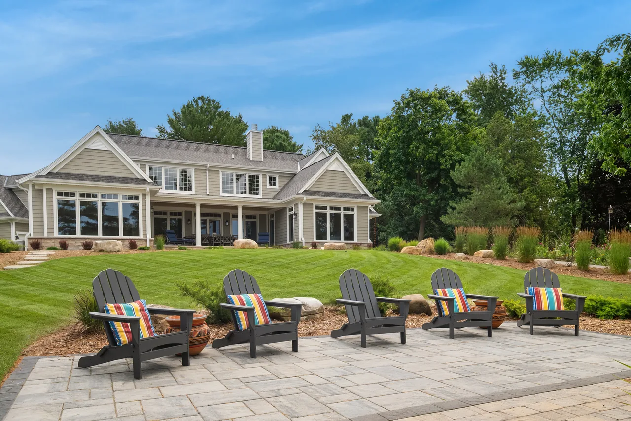 Landscaped home with a patio and Adirondack chairs