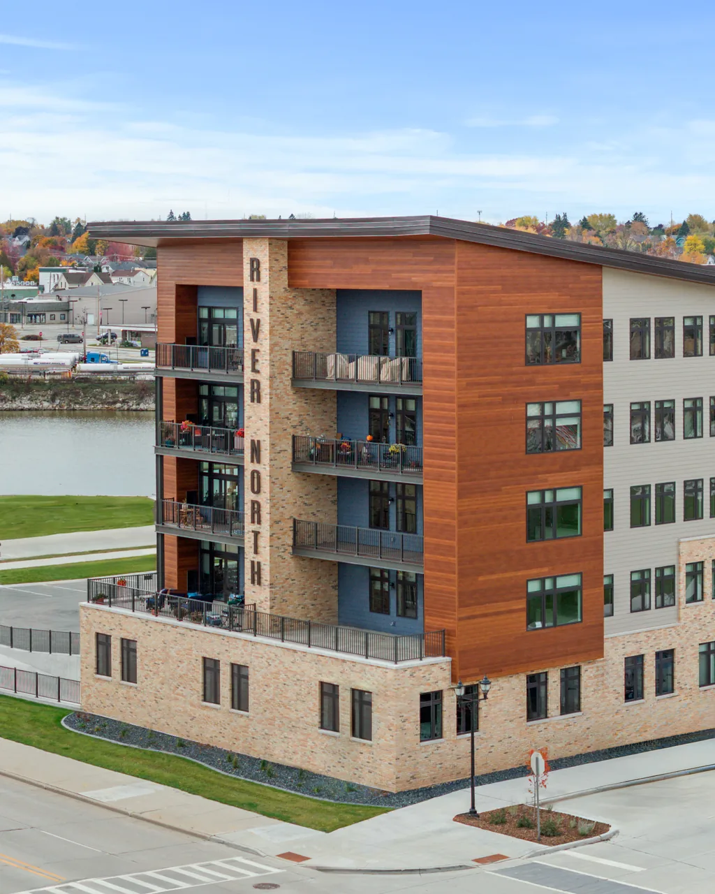 River North building with wood and stone exterior overlooking the river