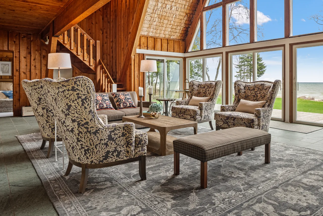 Wood-lined waterfront lounge with patterned wingback chairs